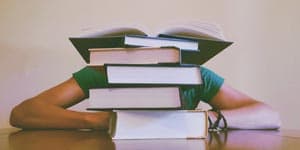 student drowning in books