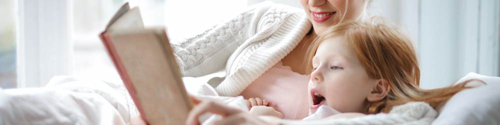 mother reading a book with daughter