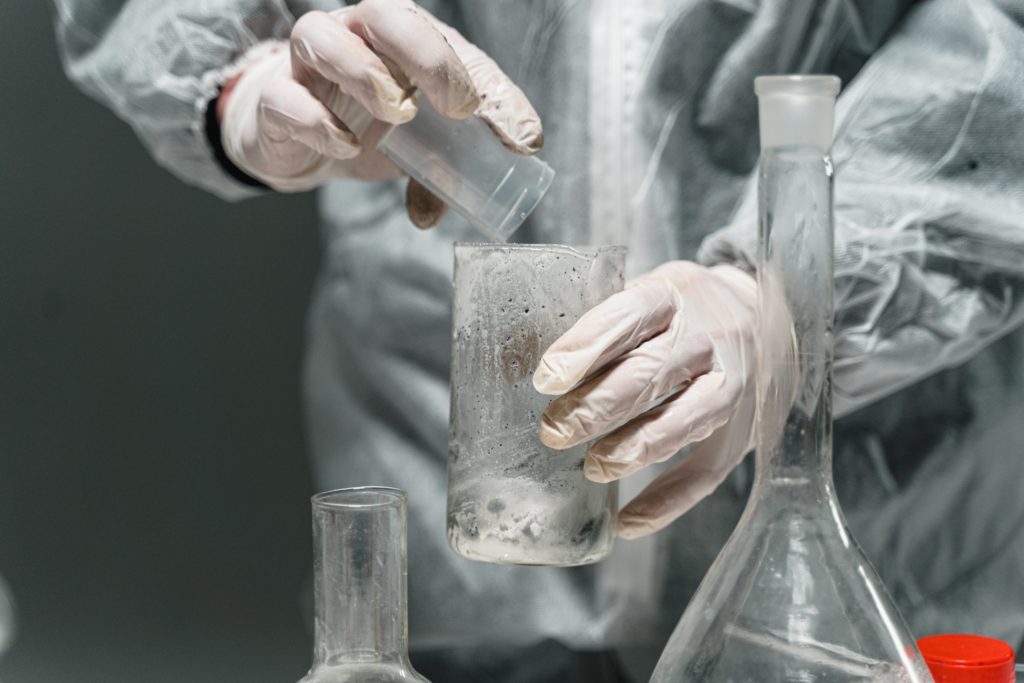 Man mixing unknown chemicals into beakers.